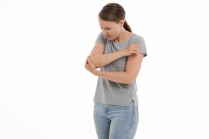 woman holding elbow in pain